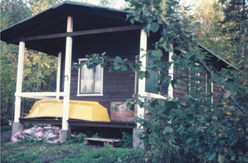 The self-built house was finally finished. It was 200 square feet in size and housed two parents and four kids, all in one room. It included a small sauna for bathing and washing. It had no running water nor electricity. We cooked with a camping gas cooker. We had an oil lamp for light. The stairs are still missing, which we built next summer.