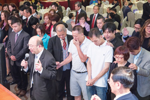吳振智牧師帶領數十名的未信者 及陪伴的信徒一同進行決志禱告。